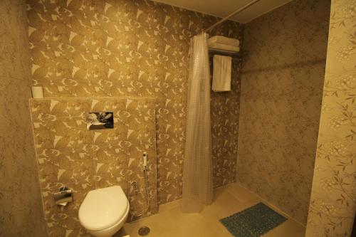 a bathroom with a toilet and a shower at Hotel Forest Avenue - Best Luxury Hotel in Dehradun in Dehradun