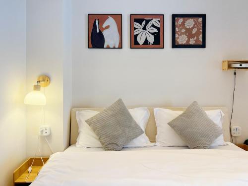 a bedroom with a white bed with four pictures on the wall at Tulips apartment in Chengdu