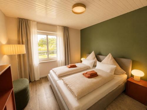a bedroom with a bed with two pillows and a window at elf-36 Apartmenthaus Bensersiel in Bensersiel