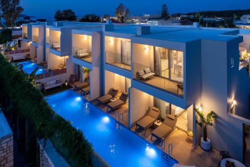 an aerial view of a building with a pool at night at Oasis Luxury Suites in Kolymbia