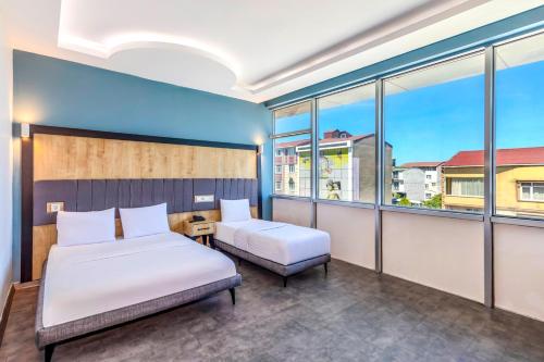 a bedroom with two beds and large windows at Dedem Hotel Express-İstanbul Airport-Round Trip Airport Service in Arnavutköy