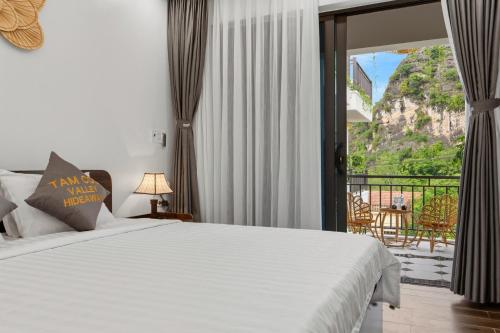 a bedroom with a bed and a view of a balcony at Tam Coc Valley Hideaway in Vũ Lâm
