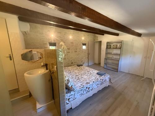 a bedroom with a bed and a sink and a tub at La Laurisienne in Lauris