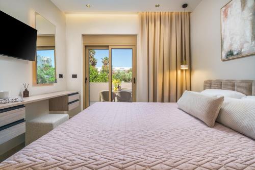 a hotel room with a large bed and a desk at MSBeach Luxury Homes - Manolis in Kos