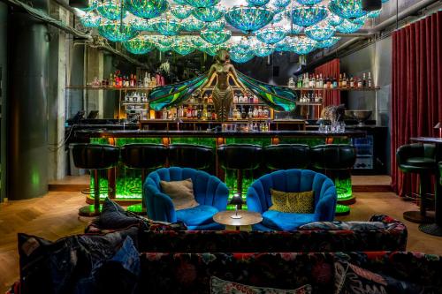 a bar with blue chairs and a bar with a green counter at Manon Les Suites Guldsmeden in Copenhagen