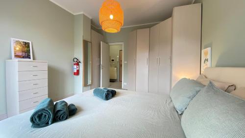 a bedroom with a white bed with blue towels on it at Collegno Centro - Il Bumbunin... in Collegno