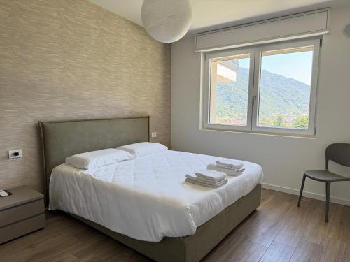 a bedroom with a bed with a window and a chair at BedE-Bike Apartments in Casazza