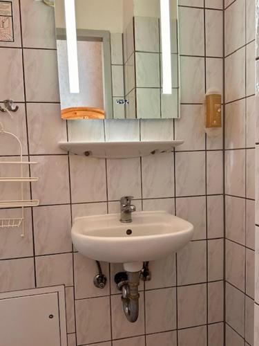 a bathroom with a sink and a mirror at Hotel Pension Bella in Berlin