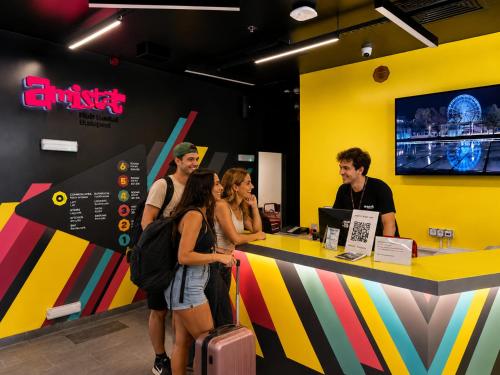 a group of people standing around a counter in a store at AMISTAT Hub Hostel Budapest in Budapest