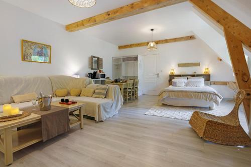 a living room with a couch and a bed at Suite Maraval Chez L'habitant in Trélissac