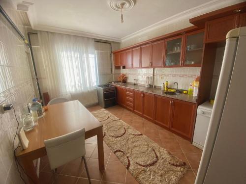 a kitchen with wooden cabinets and a wooden table with a tableablish at Nature Gate Airport Hotel in Arnavutköy