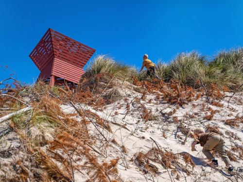two men are climbing up a sand hill at Blokhus Feriecenter in Blokhus