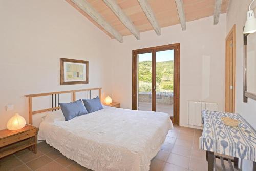 a bedroom with a bed and a table and a window at Villa Font in Artá