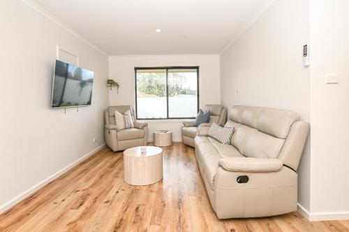 a living room with a couch and a table at Kingscote Getaway Kangaroo Island in Kingscote