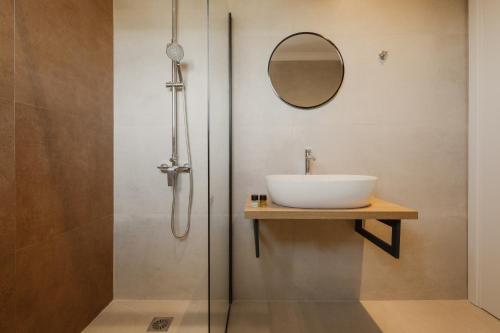 a bathroom with a sink and a shower with a mirror at Cavo Notos Beach Hotel in Kavos