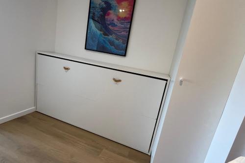 a white cabinet in a room with a painting on the wall at Studio with balcony and pool in La Baule in La Baule