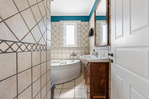 a bathroom with a tub and a sink and a bath tub at VK Villas in Apolpaina