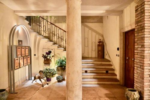 a hallway with stairs and a column with plants at Palazzo Cavalli Pasquini in Verona