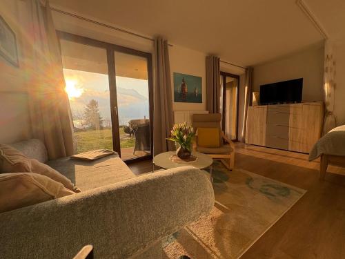 ein Wohnzimmer mit Sofa und großem Fenster in der Unterkunft Inspiration - zwei Terrassen, Seeblick, privater Garten in Altmünster