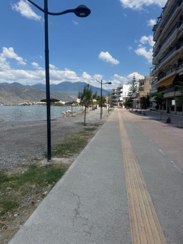 a sidewalk next to a beach with a street light at Aquamarine - Beach Flat in Itea