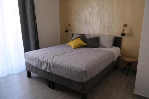 a bedroom with a large bed with yellow pillows at Nel Corso del Sogni Sicily Center Rooms in Campofelice di Roccella