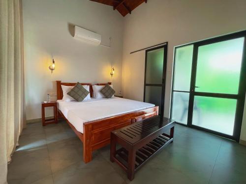 a bedroom with a bed and a large window at Yala Hideaway in Tissamaharama