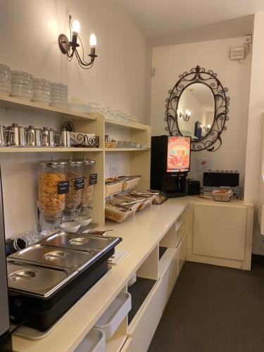 a kitchen with a counter with a sink and a mirror at Hôtel Le Mozart in Aix-en-Provence