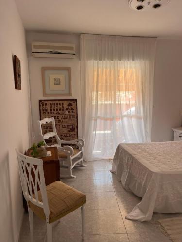 a bedroom with a bed and a chair and a window at Lydia Cabo Cope in Calabardina