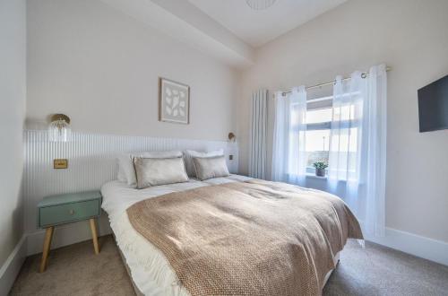 a white bedroom with a large bed with a window at Number 6 in Margate