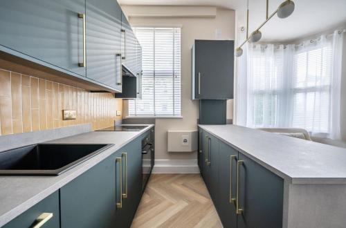 a kitchen with blue cabinets and a sink at Number 6 in Margate