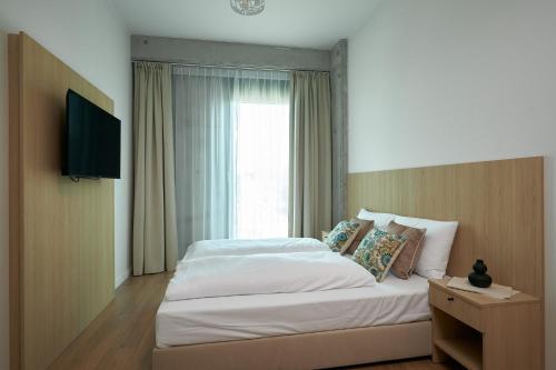 a bedroom with a large bed and a window at Aparthotel Symphony Krakowska 35 by INA in Wrocław