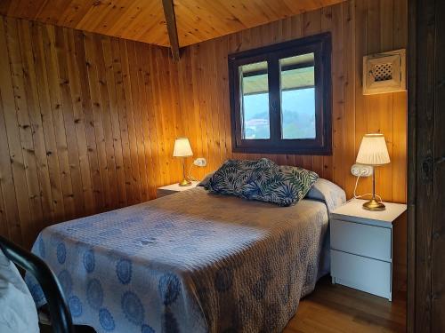 a bedroom with a bed with two lamps and a window at La Xana Ribadesella in Ribadesella