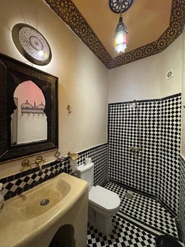 a bathroom with a toilet and a sink and a tub at Riad Dar Fatima in Merzouga