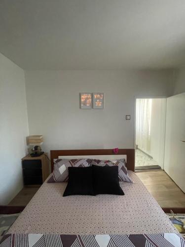 a bedroom with a large bed with black pillows at Apartman Pejovic N in Smederevo