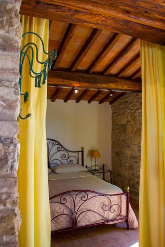 a bedroom with a bed in a stone wall at Colombaio di Cencio in Gaiole in Chianti