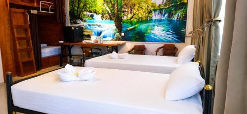 two beds in a room with a painting on the wall at 449 Airport Phuket in Nai Yang Beach