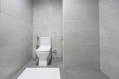 a bathroom with a white toilet in a stall at S by Z Hotels, HSR in Bangalore