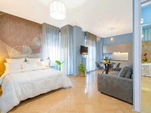 a bedroom with a large bed and a couch at City Gate - luxury suites in Bari