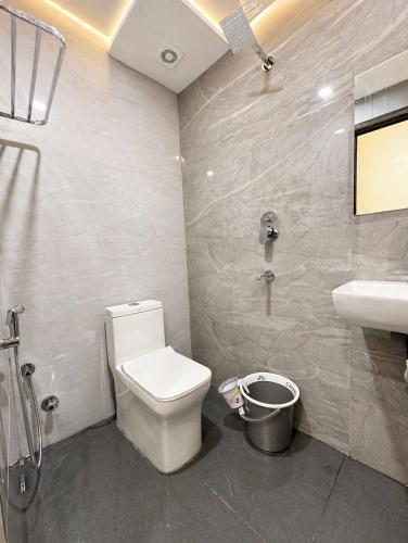a bathroom with a toilet and a sink and a shower at Hotel Lime Wood Mangaluru in Mangalore