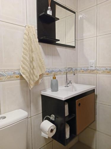 a bathroom with a sink and a toilet at Aluguel casa azul in Capão da Canoa
