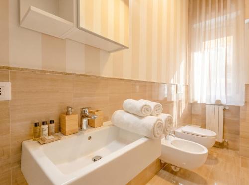 a white bathroom with a tub and a toilet at City Gate - luxury suites in Bari