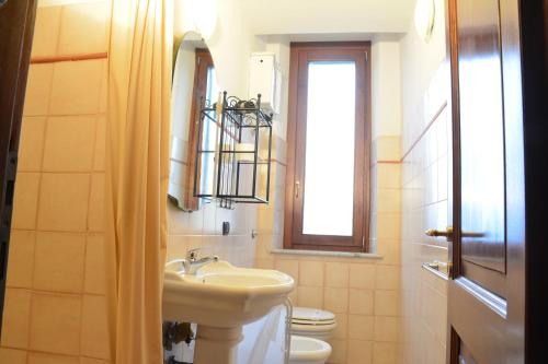 ein Bad mit einem Waschbecken, einem WC und einem Fenster in der Unterkunft Villa Regina in Amelia