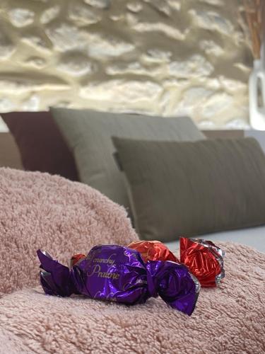 a purple bow tie sitting on top of a bed at El Somni de Paqui Apartamentos Boutique Only Adults in Alfafara
