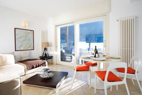 - un salon avec un canapé et une table dans l'établissement Laglio Apartment, à Laglio