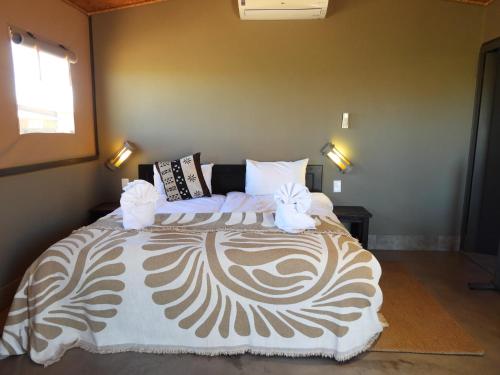 a bedroom with a bed with two stuffed animals on it at Soft Adventure Camp in Solitaire