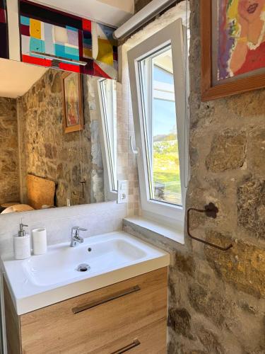 ein Badezimmer mit Waschbecken und Fenster in der Unterkunft La Ventanita Del Campo in La Cavada