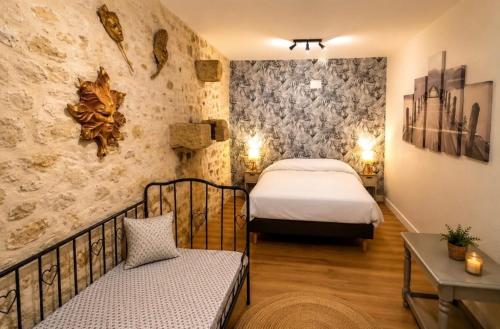 a bedroom with a bed and a couch in a room at le Logis d'Argenson in Beaulieu-sous-Parthenay