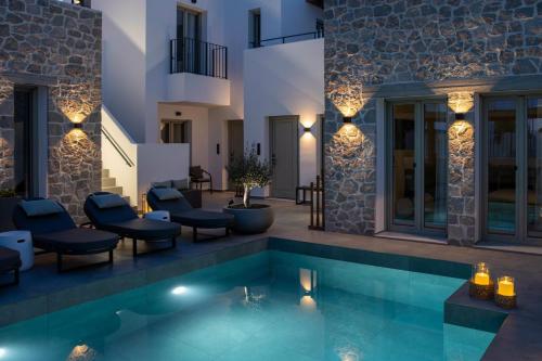 a villa with a swimming pool at night at Kalea Suites in Pollonia