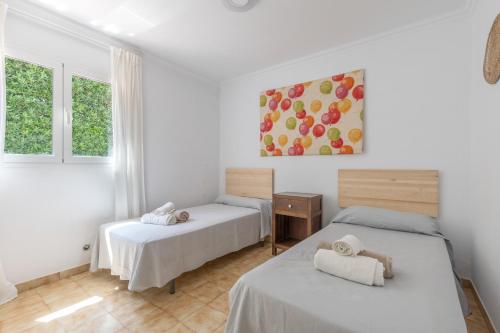 two beds in a room with a painting on the wall at Villa Sea Lights 89b in Son Bou