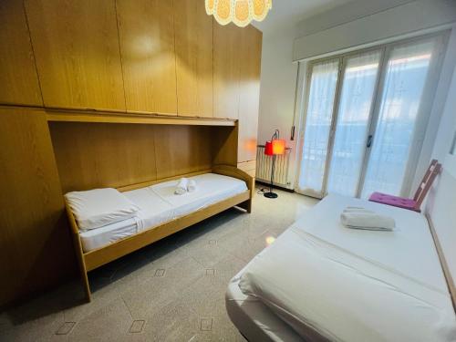 a bedroom with two beds and a large window at Suite Excelsior - Bordighera in Bordighera